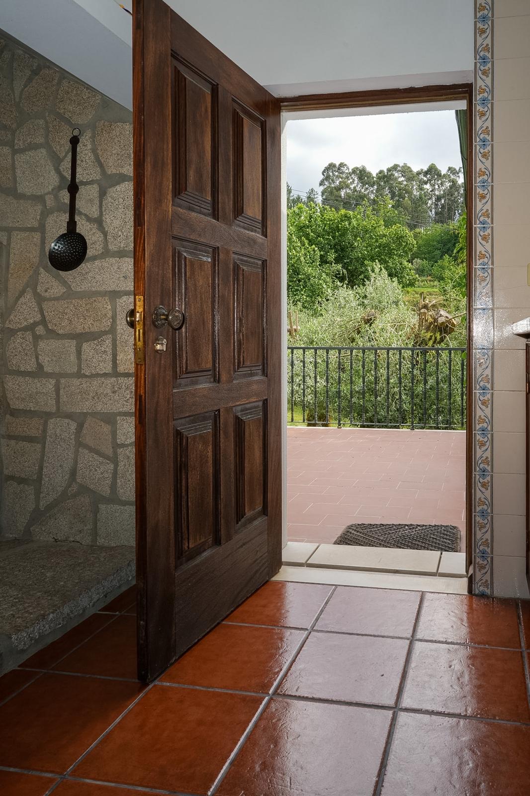 Casa da Pedrada — entrada de pedra com madeira